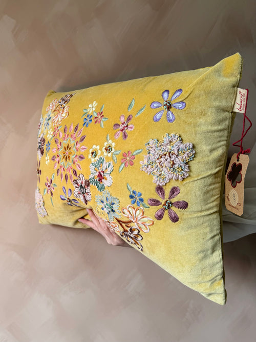 Geel kussen met geborduurde bloemen
